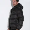 Hombre de perfil derecho, luciendo la Chaqueta Puffer Code 22 en color negro con capucha.