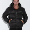 Hombre con las manos en los bolsillos, luciendo la Chaqueta Puffer Code 22 en color negro.