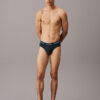 Modelo de pie con slip Calvin Klein Cotton Stretch QY5 en color azul oscuro, vista frontal