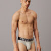 Modelo de pie con slip Calvin Klein Intense Power QTK en gris, vista frontal completa