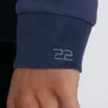 Detalle del logotipo Code 22 en el puño de la sudadera azul