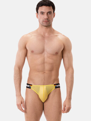 Hombre con slip Barcode Berlin Regiro Pride amarillo de frente, con cinturilla arcoíris.