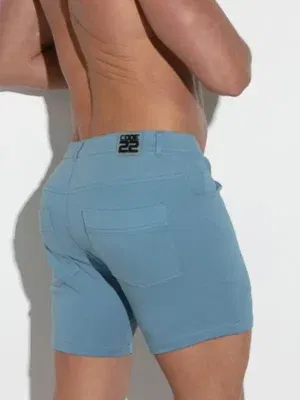 Detalle del logo Code 22 sobre short azul petróleo con bolsillos traseros de inspiración denim