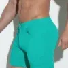 Vista lateral del short teal Code 22, con diseño stretch y color vibrante para looks atrevidos