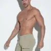Modelo mostrando el lateral del pantalón corto cargo khaki de Code 22.