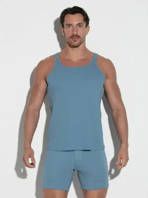 Modelo de frente con Tanktop Code 22 Train Petrol ajustado, mostrando el pecho y el logo bordado