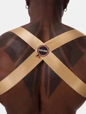 Detalle macro cruce espalda arnés dorado con parche logo Barcode Berlin multicolor