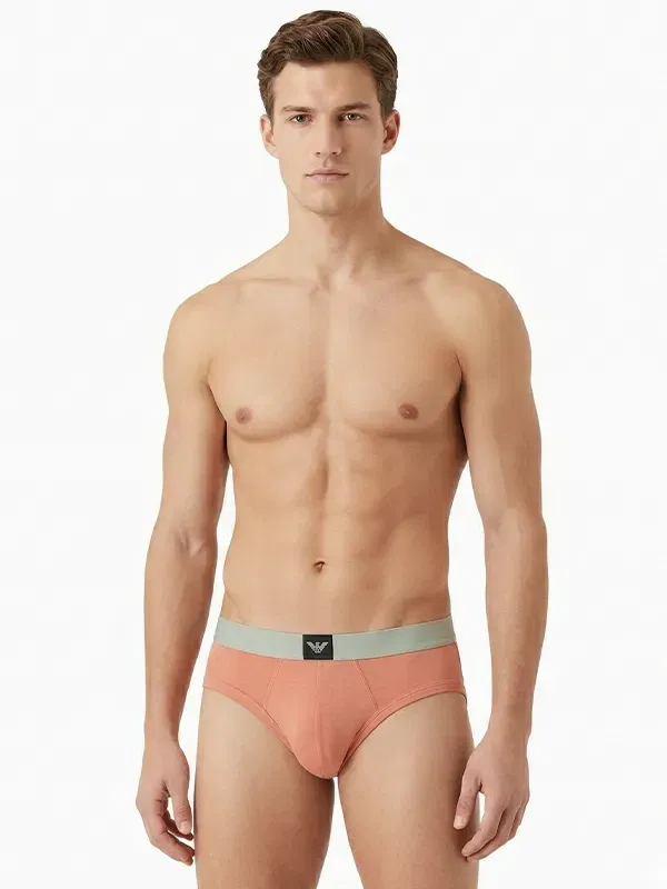 Slip hombre negro Emporio Armani, cinturilla coral con etiqueta águila centrada, vista frontal.