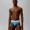Hombre vistiendo calzoncillo slip Calvin Klein Icon Cotton Stretch en color azul cian sin pernera.
