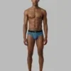 Hombre llevando slip Calvin Klein Low Rise Graphic Monogram estampado de logotipos en color azul verdoso con goma ancha.