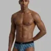 Hombre llevando slip Calvin Klein Low Rise Graphic Monogram estampado de logotipos en color azul verdoso con goma ancha.