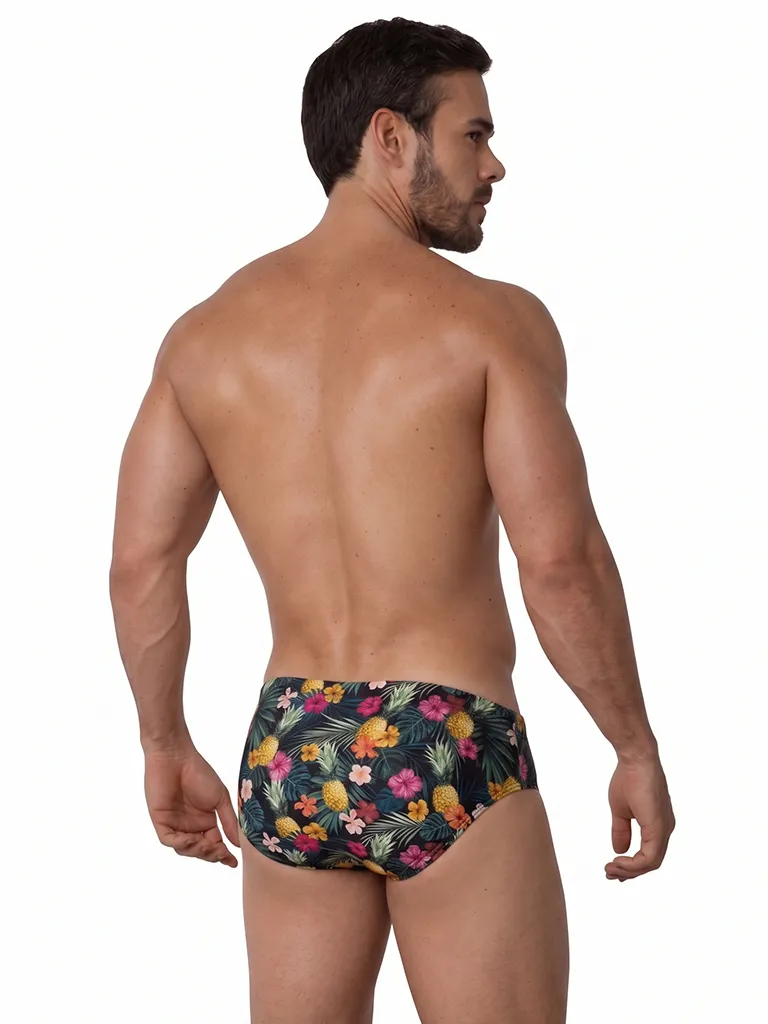 Vista frontal de bañador slip con estampado de piñas e hibiscos sobre fondo oscuro — BLU2553 Beachbrief Olaf Benz