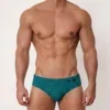 Vista frontal completa de bañador slip verde esmeralda con líneas ondulantes — BLU2554 Beachbrief Olaf Benz