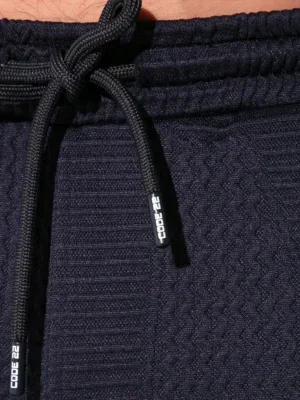 Detalle puntas de cordón con logo Code 22 en pantalón largo azul marino