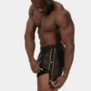 Modelo con short Fuad negro amarillo de Barcode Berlin abriendo los botones laterales