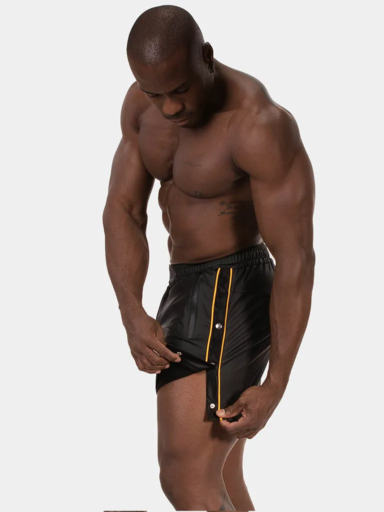 Modelo con short Fuad negro amarillo de Barcode Berlin abriendo los botones laterales