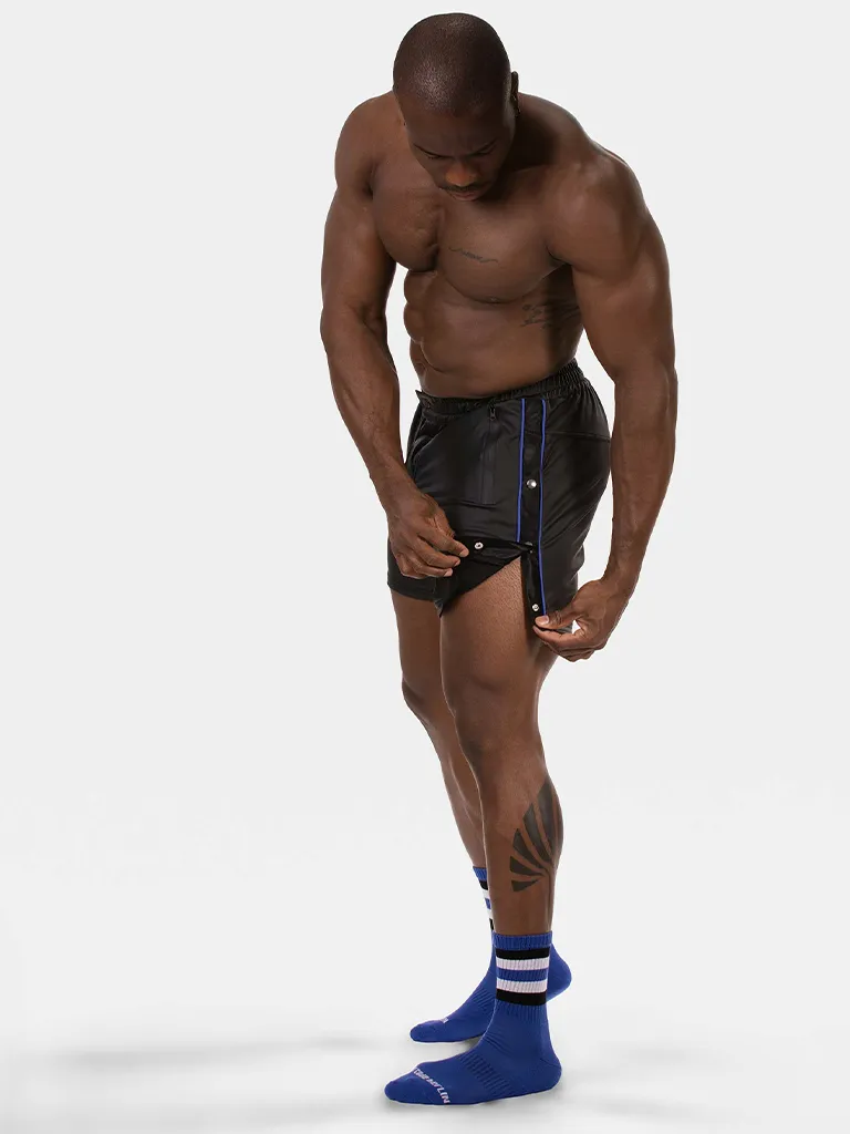Modelo con short Fuad negro royal de Barcode Berlin abriendo los botones laterales