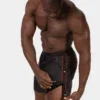 Modelo con short efecto piel negro rojo Fuad de Barcode Berlin abriendo los botones laterales