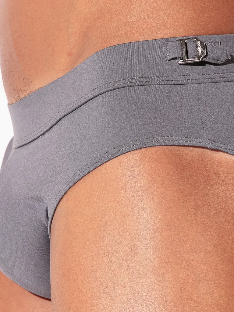 Detalle hebilla lateral Code 22 grabada en cintura bañador slip Amsterdam Gris — vista close-up