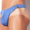 Modelo de frente con brazos cruzados luciendo tanga de baño Code 22 Amsterdam azul