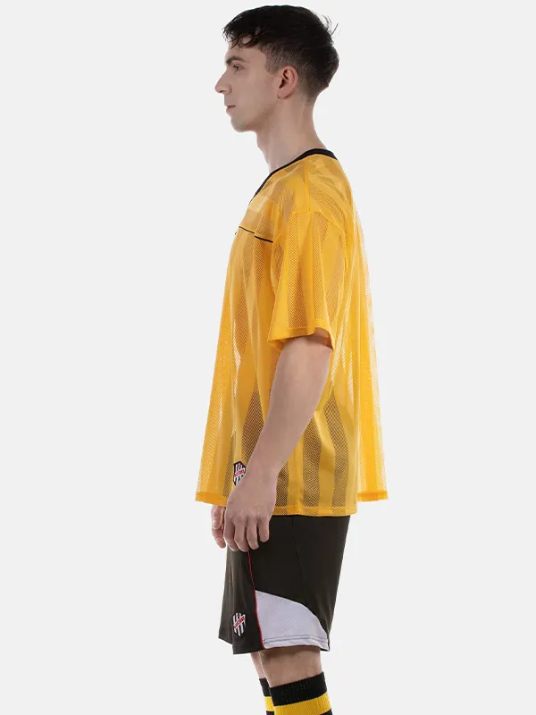 Vista lateral de la camiseta de rejilla oversize Aksel amarilla y negra de Barcode Berlin