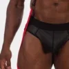 Detalle inferior del chaleco arnés Oden de Barcode Berlin con tiras rojas y ropa interior negra